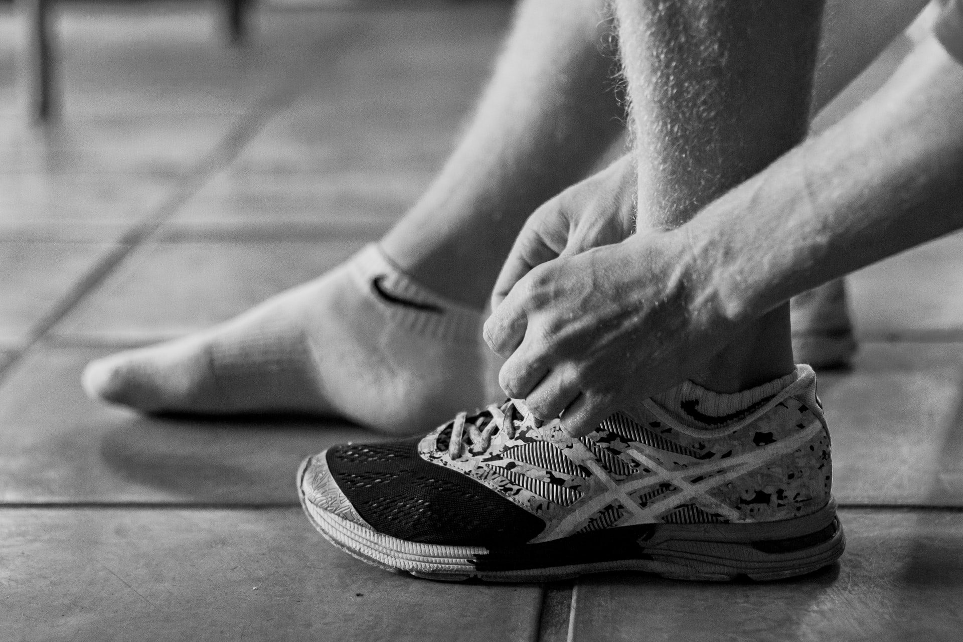 man lacing up runners